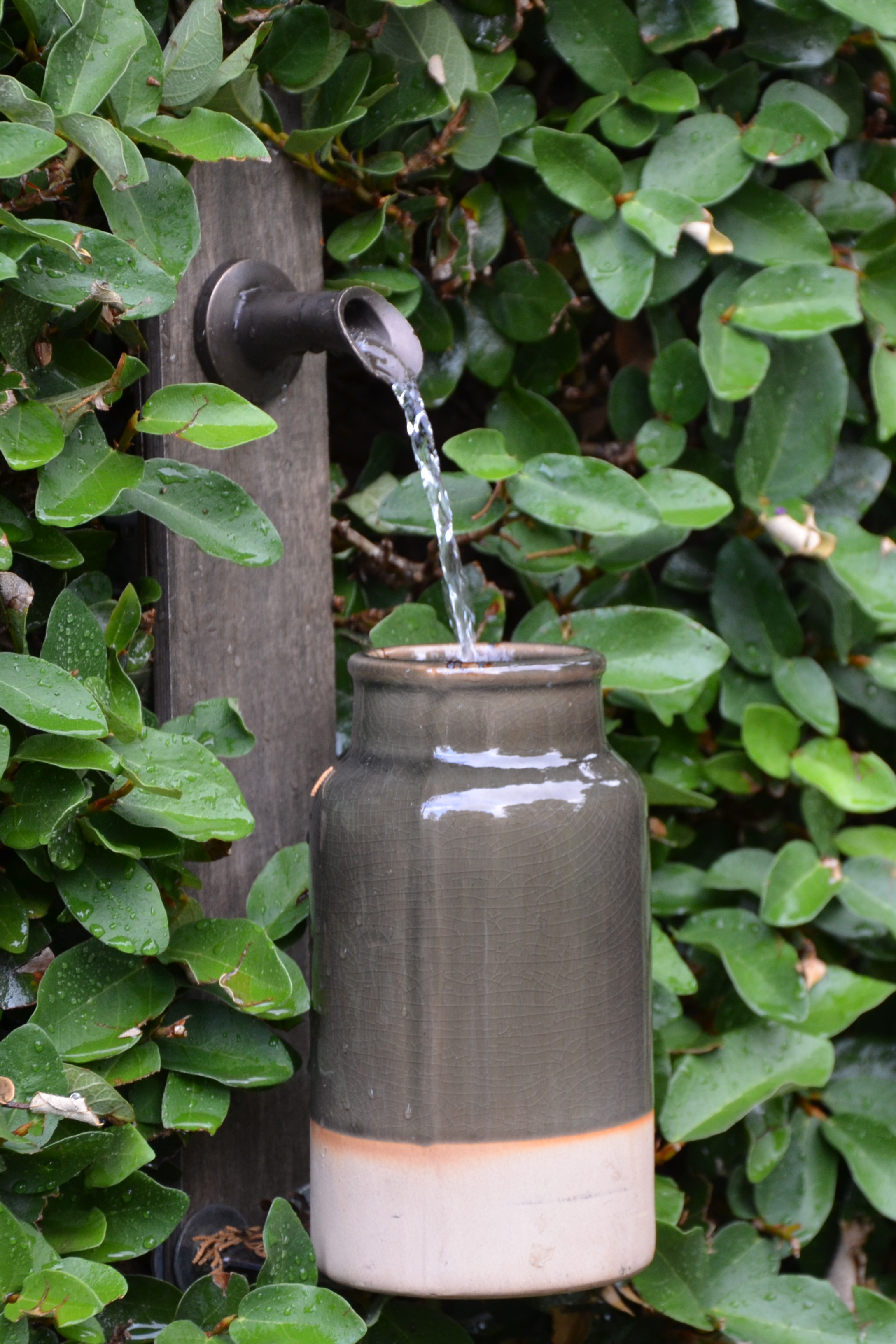 small Oona bronze fountain spout on a stone background